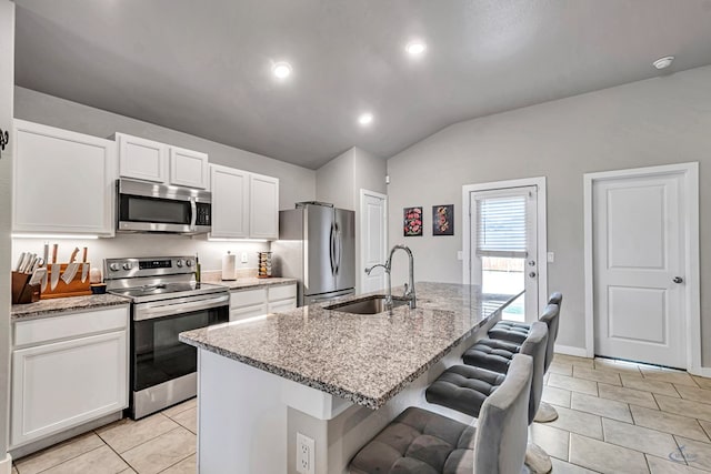 1320 E 94th St, Odessa, TX 79765 - kitchen with stainless steel appliances, light tile patterned floors, white cabinets, light stone countertops, and vaulted ceiling