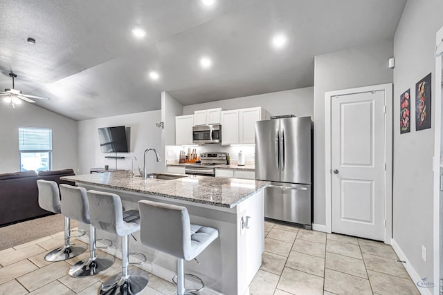 1320 E 94th St, Odessa, TX 79765 - kitchen with stainless steel appliances, a breakfast bar area, white cabinetry, ceiling fan, and open floor plan