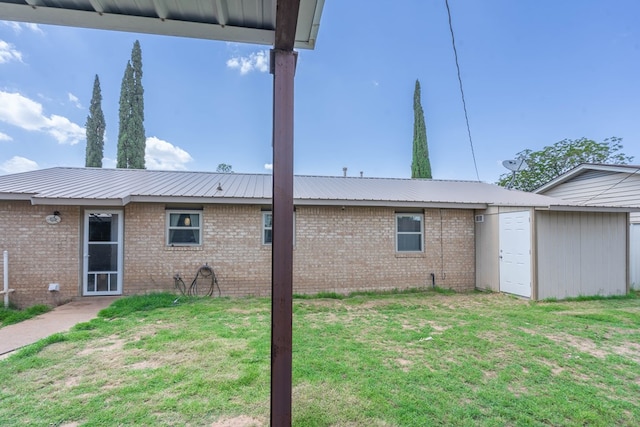 1714 E 53rd St, Odessa, TX 79762 - view of side of home with a yard, brick siding, and a metal roof