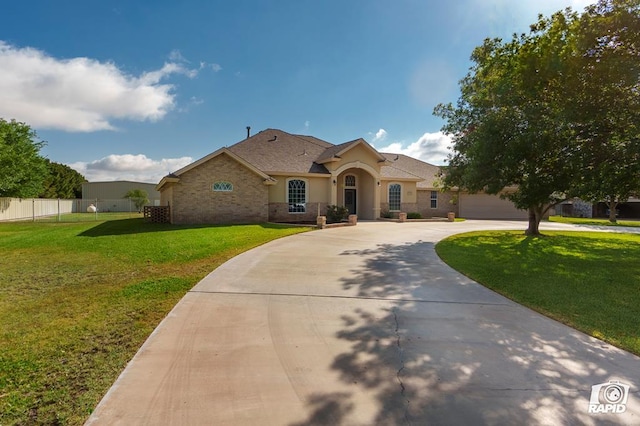 view of front facade with curved driveway, stucco siding, a shingled roof, a garage, and brick siding