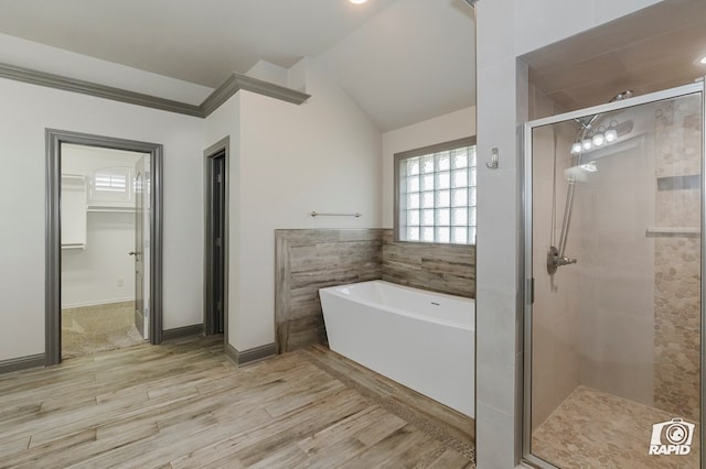 full bath featuring a shower stall, a freestanding bath, wood finished floors, lofted ceiling, and baseboards