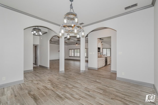 unfurnished dining area with arched walkways, ceiling fan, light wood-type flooring, baseboards, and crown molding