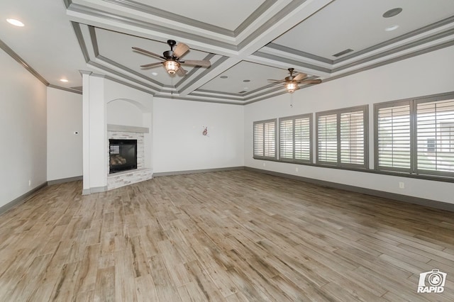unfurnished living room with a ceiling fan, coffered ceiling, ornamental molding, light wood-style flooring, and a fireplace