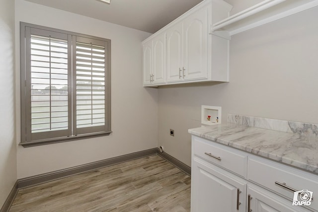 clothes washing area featuring washer hookup, cabinet space, light wood-style flooring, electric dryer hookup, and baseboards