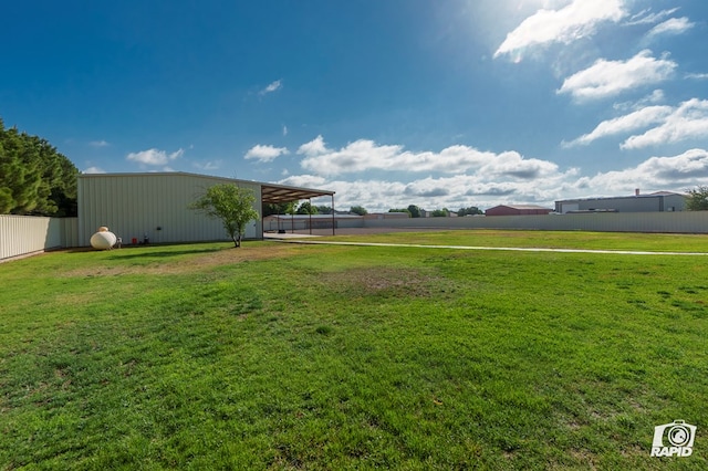 view of yard with a pole building, an outbuilding, and a carport