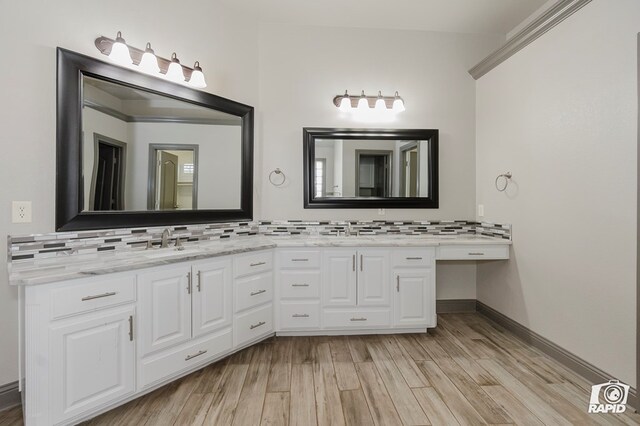bathroom with wood finished floors, backsplash, and double vanity
