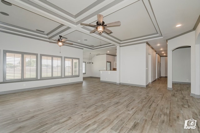 unfurnished living room featuring a ceiling fan, crown molding, arched walkways, light wood-style flooring, and baseboards