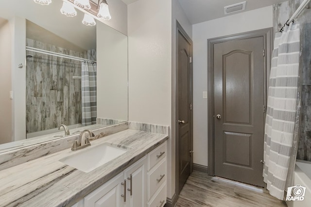 bathroom featuring curtained shower, wood finished floors, and vanity