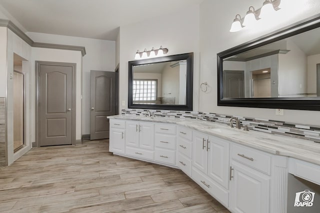 bathroom featuring wood finished floors, double vanity, decorative backsplash, and a stall shower
