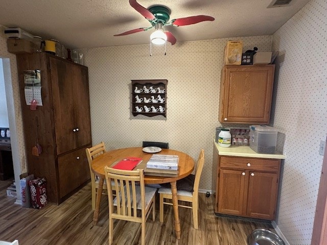 1013 Peachtree Cir, Alpine, TX 79830 - dining space with wood finished floors, a ceiling fan, and wallpapered walls