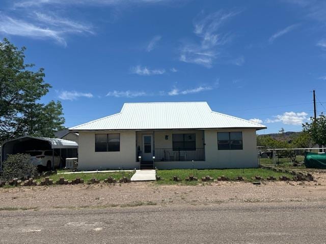 1013 Peachtree Cir, Alpine, TX 79830 - view of front of house with covered porch, stucco siding, a carport, and a metal roof