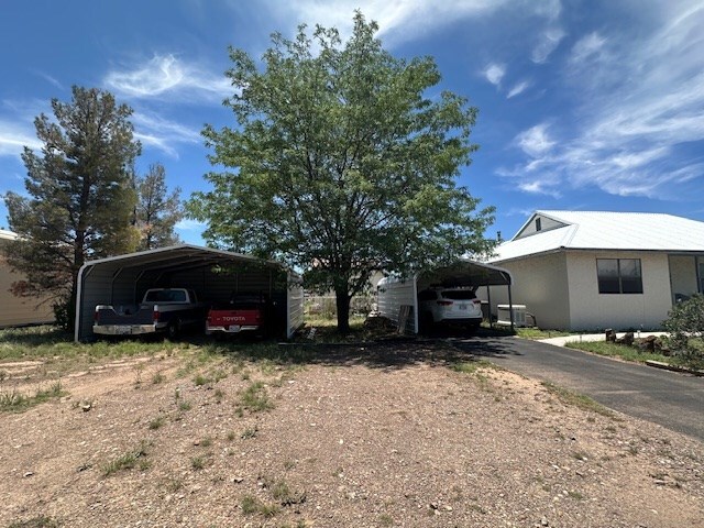 1013 Peachtree Cir, Alpine, TX 79830 - view of front of property with covered porch, a detached carport, stucco siding, and a metal roof
