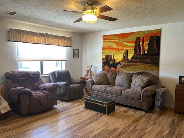 1013 Peachtree Cir, Alpine, TX 79830 - living area featuring wood finished floors, ceiling fan, and a textured ceiling