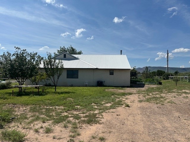 1013 Peachtree Cir, Alpine, TX 79830 - view of home's exterior with a metal roof, a mountain view, and a yard