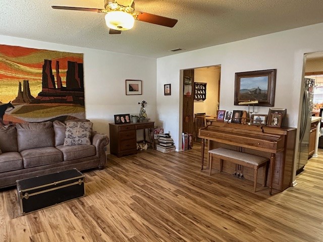 1013 Peachtree Cir, Alpine, TX 79830 - living room with light wood finished floors, ceiling fan, and a textured ceiling
