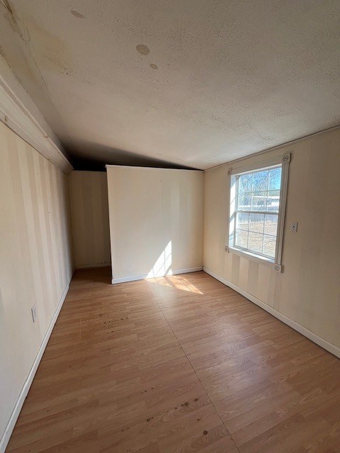 spare room featuring hardwood / wood-style floors and a textured ceiling