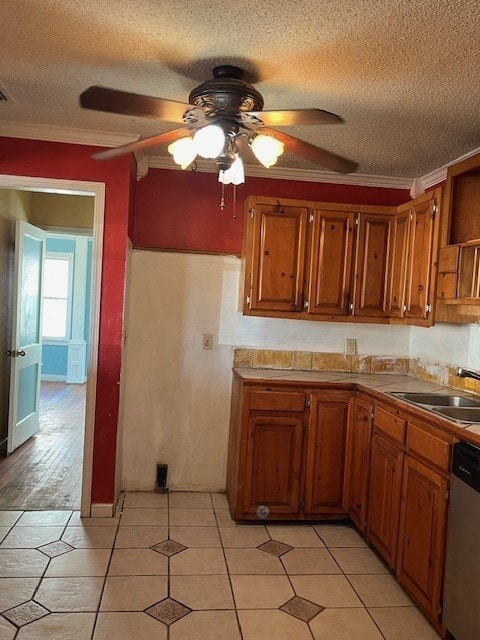 kitchen with a textured ceiling, dishwasher, ceiling fan, and sink