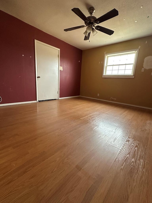 spare room with ceiling fan and light wood-type flooring