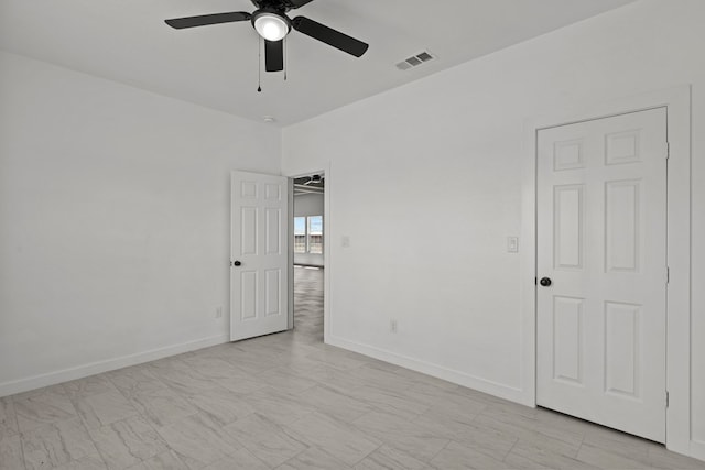 unfurnished room with a ceiling fan and baseboards