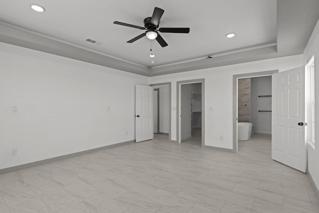 unfurnished bedroom featuring recessed lighting, a spacious closet, a raised ceiling, baseboards, and ceiling fan