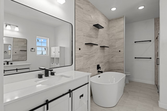 bathroom featuring a freestanding bath, recessed lighting, baseboards, and vanity