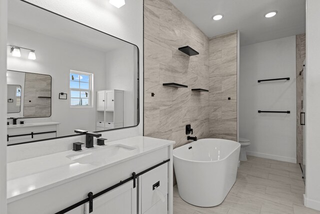12645 W Maria Dr, Odessa, TX 79764 - bathroom featuring a freestanding bath, recessed lighting, baseboards, and vanity