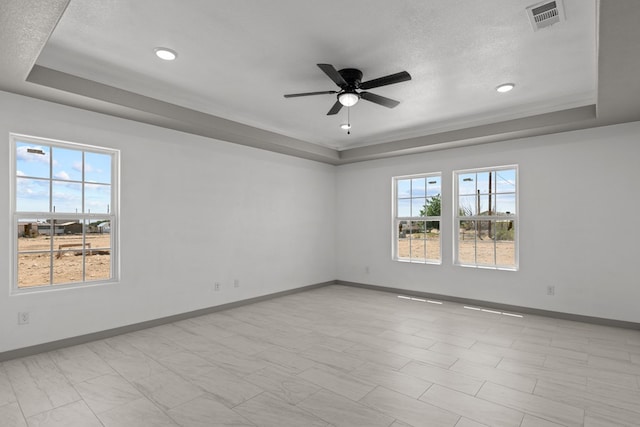 spare room with a tray ceiling, baseboards, a ceiling fan, a textured ceiling, and recessed lighting