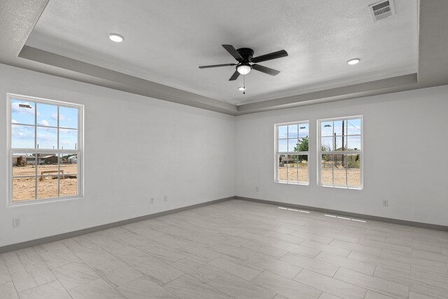 12645 W Maria Dr, Odessa, TX 79764 - spare room with a tray ceiling, baseboards, a ceiling fan, a textured ceiling, and recessed lighting