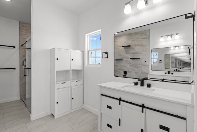 bathroom with a stall shower, baseboards, and vanity