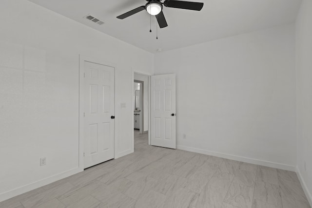 unfurnished room with a ceiling fan and baseboards