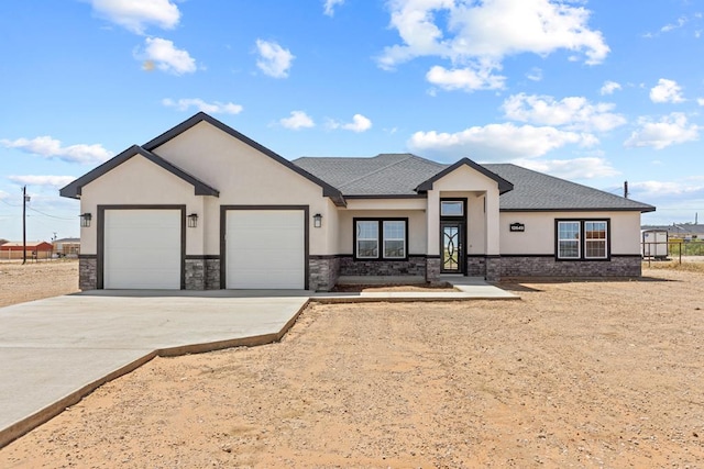 view of front facade featuring stucco siding, a garage, driveway, stone siding, and roof with shingles