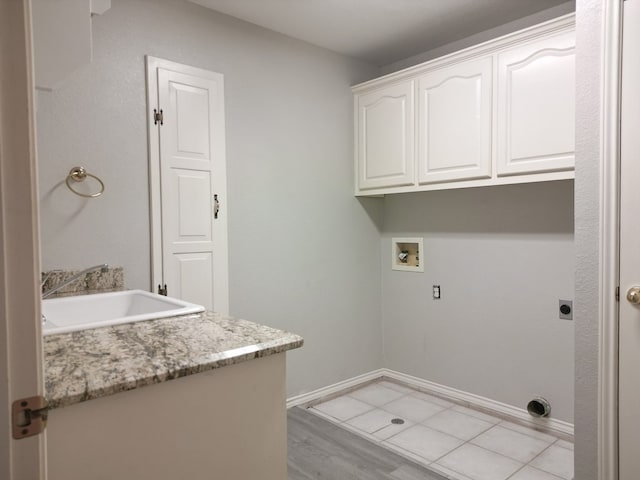 10 Lafayette Pl, Odessa, TX 79762 - laundry room featuring cabinet space, electric dryer hookup, hookup for a washing machine, baseboards, and light wood-type flooring
