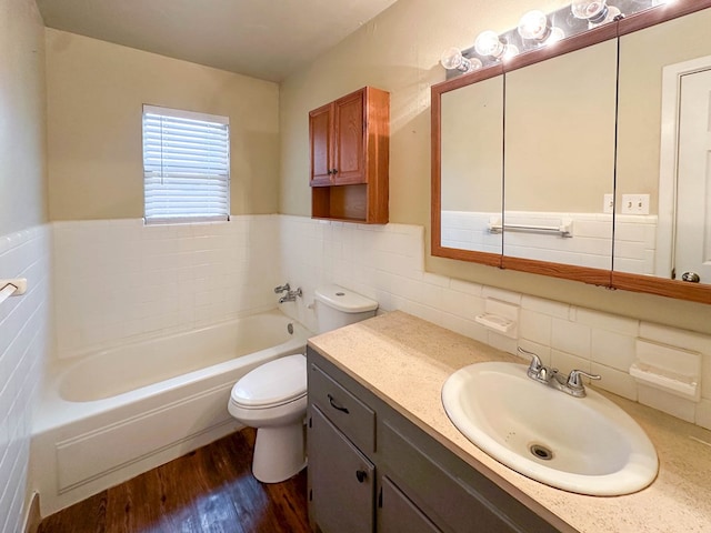 111 N 24th St, Lamesa, TX 79331 - bathroom featuring tile walls, a bath, wood finished floors, toilet, and vanity