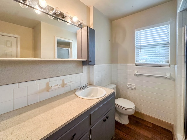 111 N 24th St, Lamesa, TX 79331 - full bath with wood finished floors, toilet, tile walls, an enclosed shower, and wainscoting