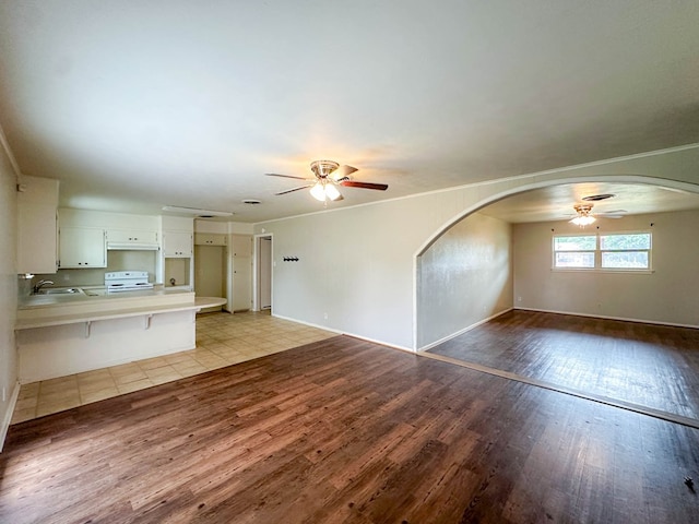 111 N 24th St, Lamesa, TX 79331 - unfurnished living room with a ceiling fan, wood finished floors, baseboards, a sink, and ornamental molding