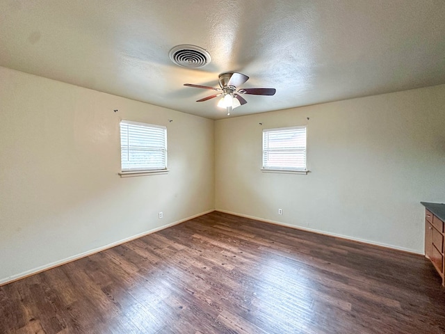 111 N 24th St, Lamesa, TX 79331 - empty room with dark wood-style floors, ceiling fan, and baseboards