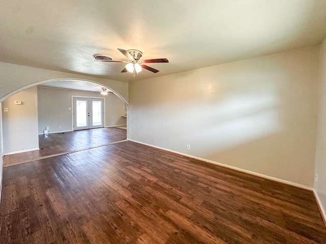 111 N 24th St, Lamesa, TX 79331 - empty room featuring arched walkways, baseboards, and dark wood-style floors