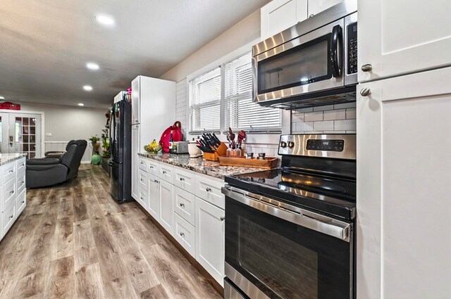 811 NW 7th St, Andrews, TX 79714 - kitchen featuring appliances with stainless steel finishes, white cabinets, light wood-style floors, and recessed lighting