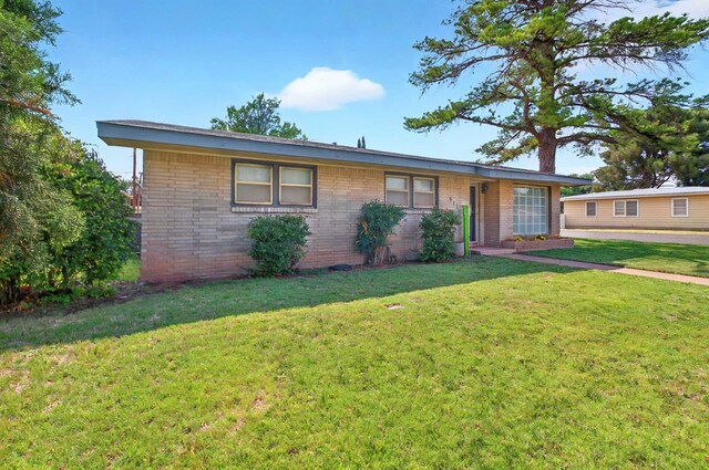 811 NW 7th St, Andrews, TX 79714 - ranch-style house with a front yard and brick siding