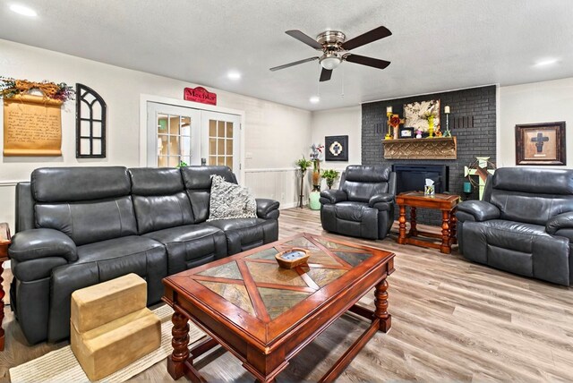 811 NW 7th St, Andrews, TX 79714 - living room with a ceiling fan, a brick fireplace, recessed lighting, light wood-style floors, and french doors