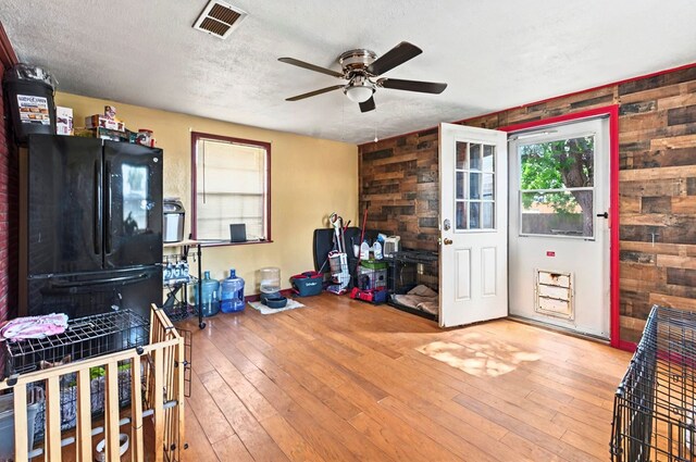 811 NW 7th St, Andrews, TX 79714 - playroom featuring a ceiling fan, a textured ceiling, wood-type flooring, and wooden walls