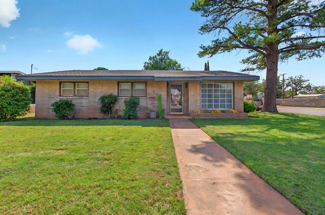 811 NW 7th St, Andrews, TX 79714 - ranch-style house featuring brick siding and a front lawn
