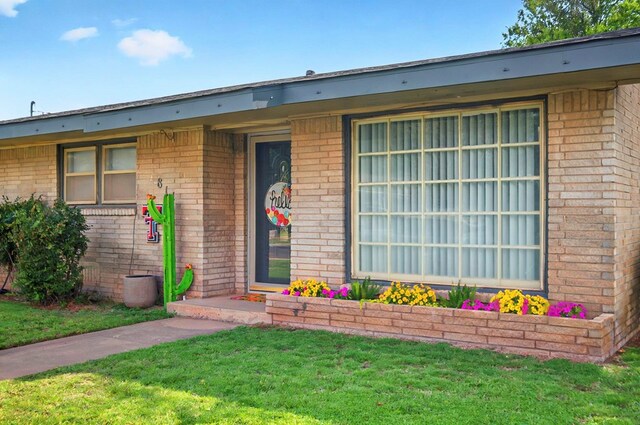 811 NW 7th St, Andrews, TX 79714 - view of front of house featuring brick siding and a front yard