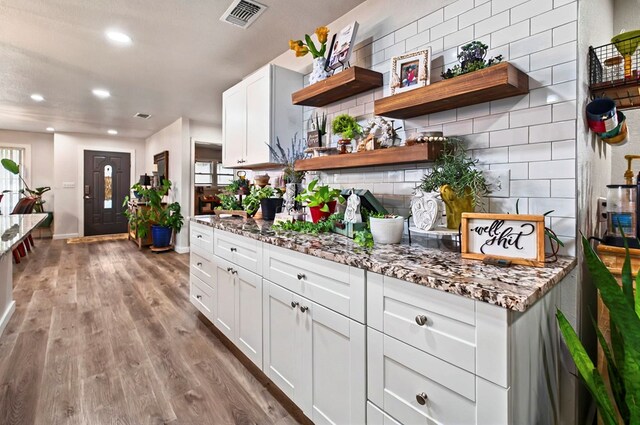 811 NW 7th St, Andrews, TX 79714 - bar with decorative backsplash, wood finished floors, baseboards, and recessed lighting