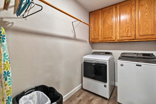 811 NW 7th St, Andrews, TX 79714 - laundry room with cabinet space, washer and clothes dryer, wood finished floors, and baseboards