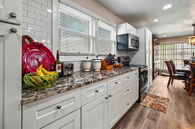 811 NW 7th St, Andrews, TX 79714 - kitchen featuring appliances with stainless steel finishes, a textured ceiling, dark wood-style flooring, white cabinets, and recessed lighting