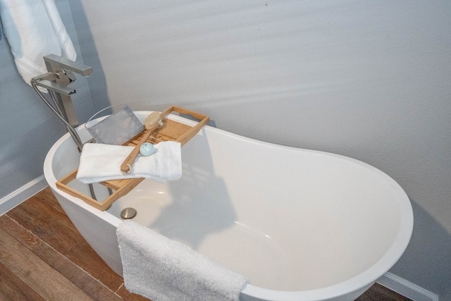 1403 E 17th St, Odessa, TX 79761 - bathroom view of baseboards, a freestanding tub, and wood finished floors