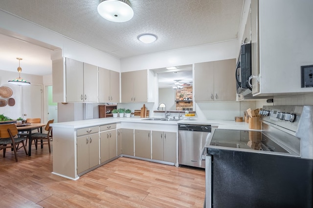 1403 E 17th St, Odessa, TX 79761 - kitchen featuring dishwasher, a sink, light wood-style flooring, light countertops, and a textured ceiling