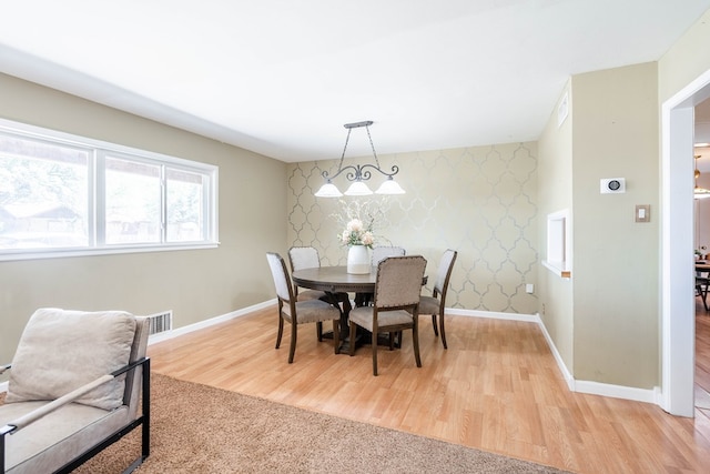 1403 E 17th St, Odessa, TX 79761 - dining space featuring wallpapered walls, baseboards, light wood-style flooring, and an accent wall