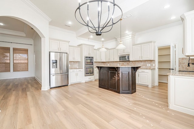 kitchen featuring decorative backsplash, stainless steel appliances, white cabinetry, and hanging light fixtures